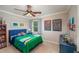 Bright bedroom with a blue bed, colorful artwork, and a ceiling fan at 4540 Saddle Se Ct, Smyrna, GA 30082
