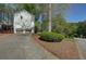 View of the exterior showing the two-car garage and driveway of this white home surrounded by beautiful landscaping at 4540 Saddle Se Ct, Smyrna, GA 30082