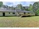 Backyard view of a house with a deck overlooking a spacious lawn and mature trees at 780 N Ola Rd, Mcdonough, GA 30252