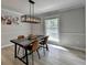 Dining room features a modern table, stylish light fixture, hardwood floors and large window at 780 N Ola Rd, Mcdonough, GA 30252