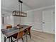 Dining room features a modern table, stylish light fixture, hardwood floors and white door at 780 N Ola Rd, Mcdonough, GA 30252