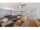 Open-concept living space with hardwood floors, a comfortable sofa, and a view of the modern kitchen at 123 Academy Ln, Canton, GA 30114