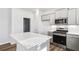 Modern kitchen featuring an island with stone countertop and stainless steel appliances, adding style and functionality at 129 Kenney Way, Locust Grove, GA 30248