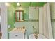 Stylish bathroom featuring green tile, vintage hardware, a clawfoot tub, and elegant vanity at 167 E Lake Se Ter, Atlanta, GA 30317