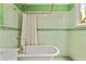 Charming bathroom with clawfoot tub, unique green tiling, and vintage-style fixtures at 167 E Lake Se Ter, Atlanta, GA 30317
