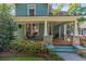Inviting front porch featuring stone columns, a wooden deck, and a relaxing porch swing at 167 E Lake Se Ter, Atlanta, GA 30317