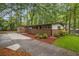 Home's brick and white siding, accented by beautiful landscaping and mature trees at 2700 Brook Park Way, Doraville, GA 30340