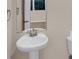 A stylish half-bathroom features a pedestal sink and a modern design at 436 Vermeer Ct, Locust Grove, GA 30248