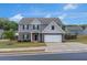 Charming two-story home with a brick and siding exterior, well-manicured lawn, and attached garage at 436 Vermeer Ct, Locust Grove, GA 30248