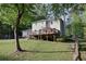 Landscaped backyard with deck, surrounded by mature trees, offers privacy and tranquility at 5083 Lambeth Nw Ct, Acworth, GA 30101