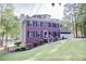 View of a two-story brick home with a chimney, black shutters, and mature trees surrounding the property at 5083 Lambeth Nw Ct, Acworth, GA 30101
