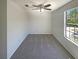 This bedroom features neutral carpeting, ceiling fan, and a window for natural light at 5537 Panola Pl, Lithonia, GA 30058