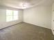This bedroom features neutral carpeting and a window for natural light at 5537 Panola Pl, Lithonia, GA 30058
