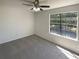 This bedroom features neutral carpeting, ceiling fan, and a window for natural light at 5537 Panola Pl, Lithonia, GA 30058