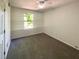 This bedroom features neutral carpeting and a window for natural light at 5537 Panola Pl, Lithonia, GA 30058