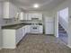 Bright kitchen featuring white appliances and cabinetry, with views into a stairwell at 5537 Panola Pl, Lithonia, GA 30058