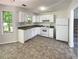 This kitchen features white cabinets and appliances and a window for natural light at 5537 Panola Pl, Lithonia, GA 30058