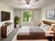Cozy staged bedroom featuring a large window, dresser, and well-lit modern lamps at 5537 Panola Pl, Lithonia, GA 30058