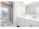 Bright bathroom with a double vanity, window and toilet and shower behind a patterned curtain at 637 Little Bear Loop, Canton, GA 30114