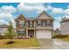 Charming two-story home featuring a stone and gray siding exterior, lush landscaping, and a two-car garage at 637 Little Bear Loop, Canton, GA 30114