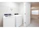 Clean laundry room with white washer and dryer and wire shelving above at 637 Little Bear Loop, Canton, GA 30114