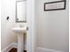 Compact powder room featuring pedestal sink and decorative wall art at 637 Little Bear Loop, Canton, GA 30114