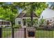 Lovely home featuring a quaint front porch, black fence, and beautiful landscaping, surrounded by mature trees at 655 Moreland Se Ave, Atlanta, GA 30316