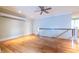 Upstairs loft area with hardwood floors, ceiling fan, and a white railing at 655 Moreland Se Ave, Atlanta, GA 30316