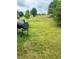 Backyard featuring a well-maintained lawn, mature trees, and a BBQ grill for outdoor cooking at 573 Emporia Loop, Mcdonough, GA 30253