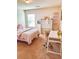 Cozy bedroom with a pink bed, a study desk, and a window providing natural light at 573 Emporia Loop, Mcdonough, GA 30253