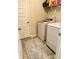 Efficient laundry area with white appliances and storage shelving above the washer and dryer at 573 Emporia Loop, Mcdonough, GA 30253