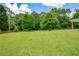 Well-manicured backyard with a fire pit area, framed by lush trees and a wooden fence at 7307 Banks Mill Rd, Douglasville, GA 30135