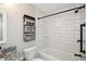 This is a bathroom featuring a shower and bath with white subway tile and matte black fixtures at 7307 Banks Mill Rd, Douglasville, GA 30135