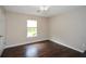 Cozy bedroom showcasing dark hardwood floors, neutral paint, and natural light from the window at 7307 Banks Mill Rd, Douglasville, GA 30135