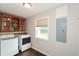 Well-lit laundry room with washer, dryer, shelving, and window view at 7307 Banks Mill Rd, Douglasville, GA 30135
