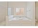 Luxurious bathroom with a soaking tub, glass block window and seamless glass shower at 1128 Bellewood Sq, Dunwoody, GA 30338