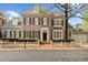 Charming two-story brick home featuring a white picket fence, shutters, and manicured landscaping at 1128 Bellewood Sq, Dunwoody, GA 30338