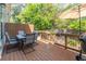 Outdoor dining deck with dining table, grill and sun umbrella surrounded by lush trees and landscaping at 1382 Doublegate Ne Dr, Atlanta, GA 30319