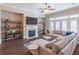 Sunlit living room with fireplace, ceiling fan, hardwood floors, and large sectional sofa at 1382 Doublegate Ne Dr, Atlanta, GA 30319