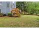 The grassy backyard features a wooden deck with stairs and a satellite dish, surrounded by lush greenery and mature trees at 1533 Fallen Leaf Sw Dr, Marietta, GA 30064