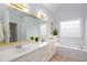 Bright bathroom featuring a double vanity, large mirror, soaking tub, and a window for natural light at 1533 Fallen Leaf Sw Dr, Marietta, GA 30064