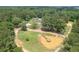 Aerial shot features a property with a pond and an island with dock, surrounded by dense trees at 204 Mt Moriah Rd, Auburn, GA 30011