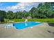 Refreshing backyard pool and lounge area surrounded by green lawn and mature trees at 204 Mt Moriah Rd, Auburn, GA 30011