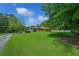 Expansive front yard featuring a well-manicured lawn and mature trees, leading up to a beautiful brick home at 204 Mt Moriah Rd, Auburn, GA 30011