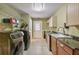 Bright laundry room featuring modern washer and dryer units, cabinetry, and a utility sink at 204 Mt Moriah Rd, Auburn, GA 30011
