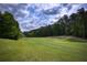 Scenic view of a lush green golf course with rolling hills and mature trees, offering a tranquil recreational setting at 300 Maple Grove Ct, Canton, GA 30114