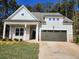 Charming one-story home featuring a light gray facade, a two-car garage and a covered porch at 3032 Farm Tract Trl, Woodstock, GA 30189