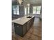 This kitchen features a gray island with a quartz countertop, stainless steel appliances, and pendant lighting at 3032 Farm Tract Trl, Woodstock, GA 30189