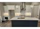 This kitchen features a large island, white cabinets, stainless steel appliances, and pendant lighting at 3032 Farm Tract Trl, Woodstock, GA 30189
