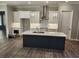 This kitchen features a large island, white cabinets, stainless steel appliances, and pendant lighting at 3032 Farm Tract Trl, Woodstock, GA 30189